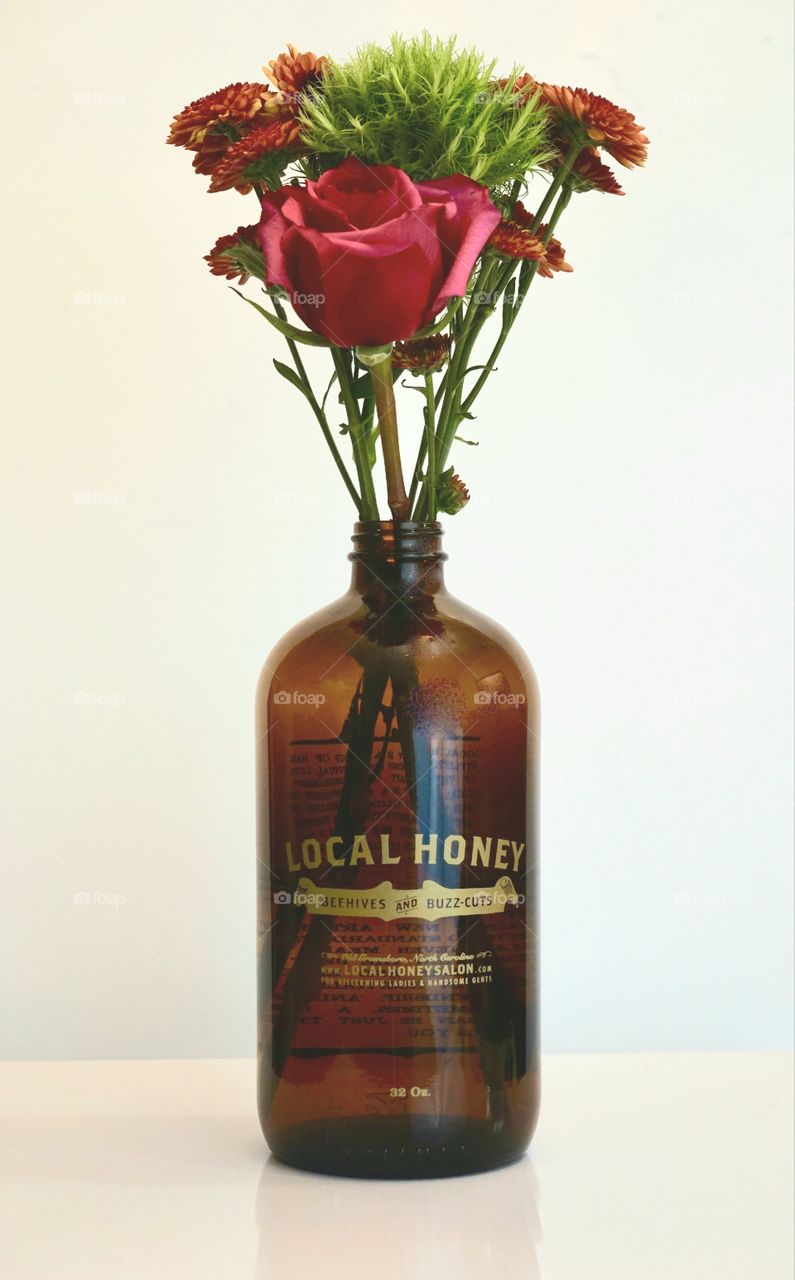 Beer growler with flowers with white background.