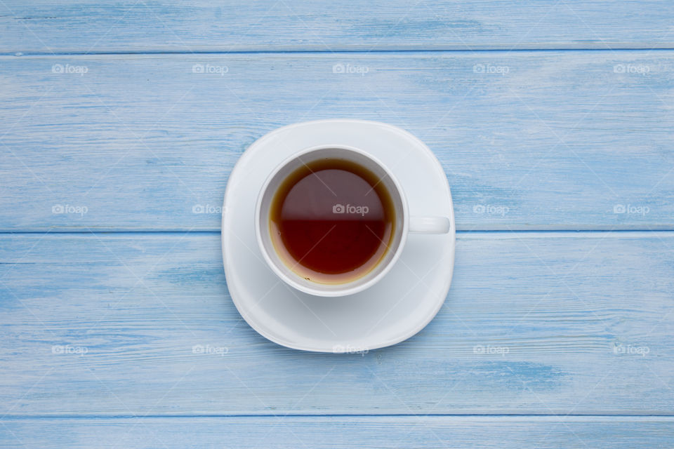 cup of tea for breakfast on a blue wood table.  morning ritual concept!