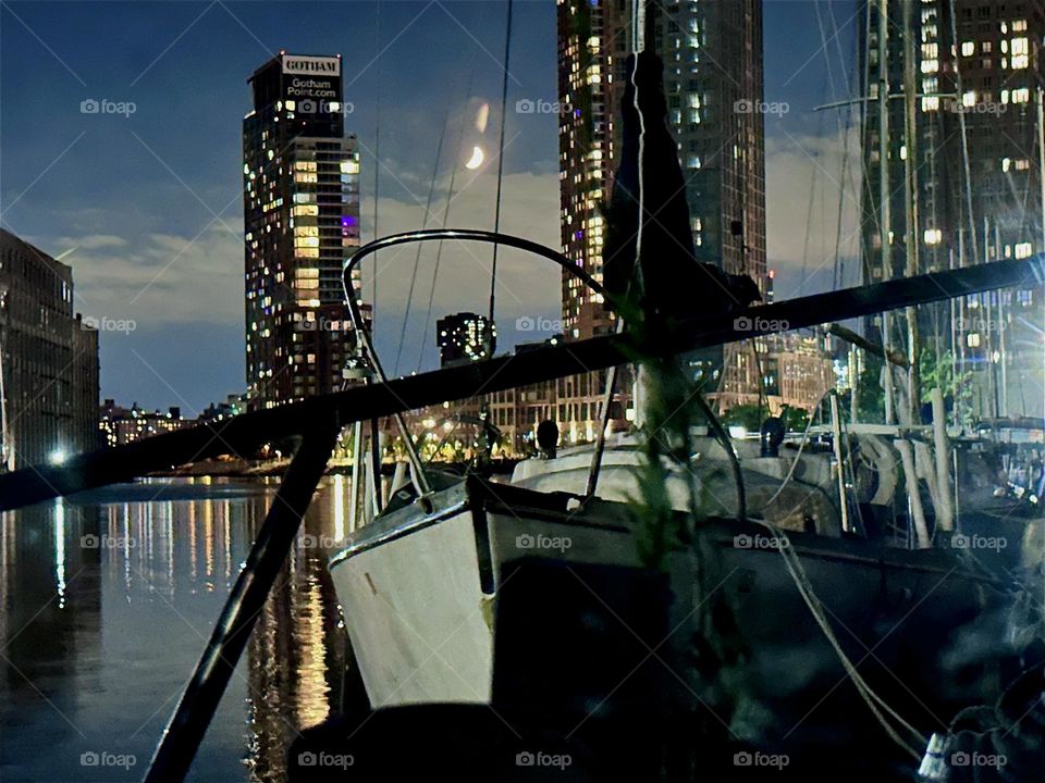 At night “Newtown Creek” by the “Pulaski Bridge” in LIC, Queens is illuminated only by the moon, the electric lights of the surrounding high rises in LIC and “Greenpoint”, Bklyn and their reflections in the “East River”. 2024. Hypnotic Productions