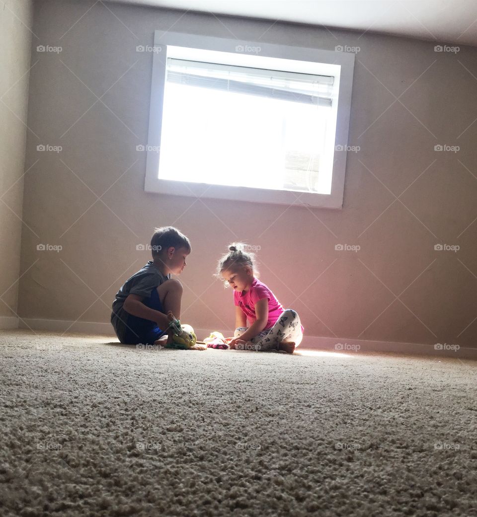 Two adorable kids playing with toy