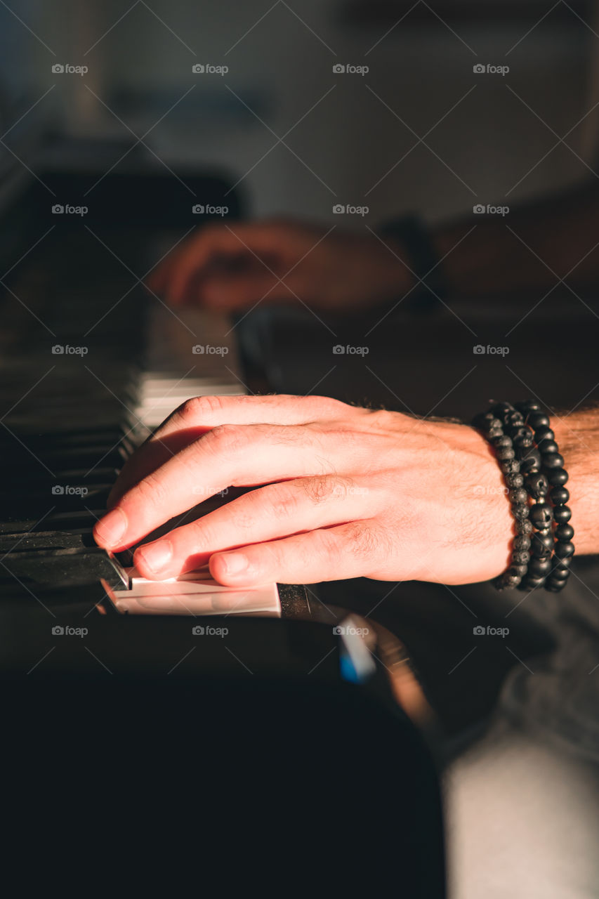 Close up on the hand of a man playing the piano