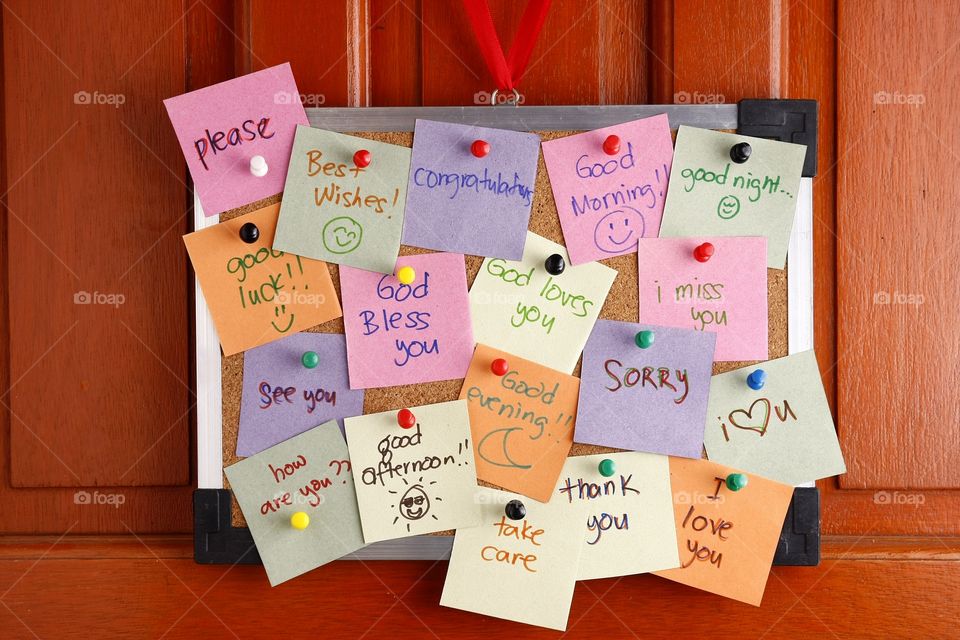 cork board with messages on colored paper