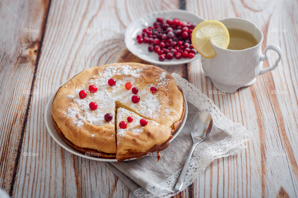 Cheesecake with cranberries and sugar on wooden background