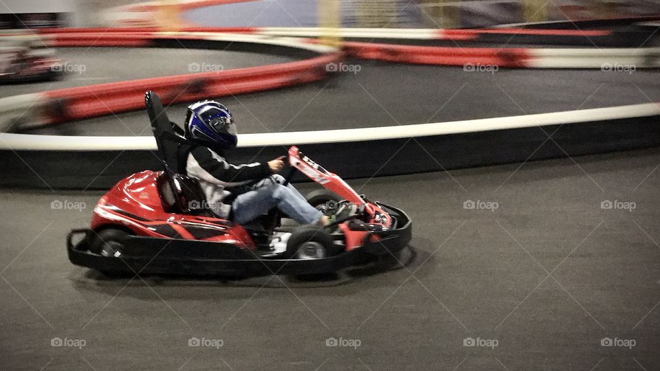 Go cart racing fast on a race track. 