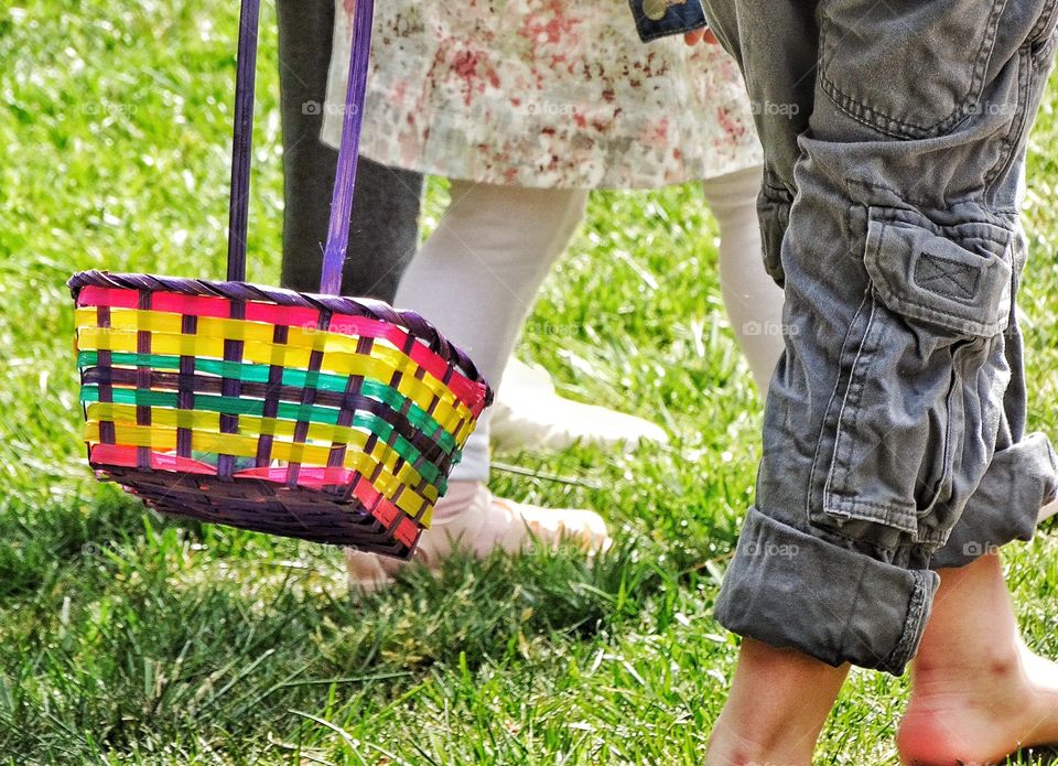 Easter Egg Hunt. Children Carrying Baskets Hunting For Easter Eggs
