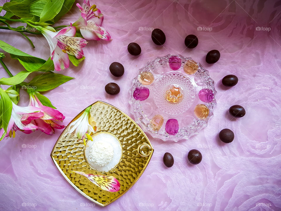 different types of chocolate on a sugar covered golden plate decorated with flowers, the white one is my personal favourite covered with coconut pieces decorated with pink flowers
