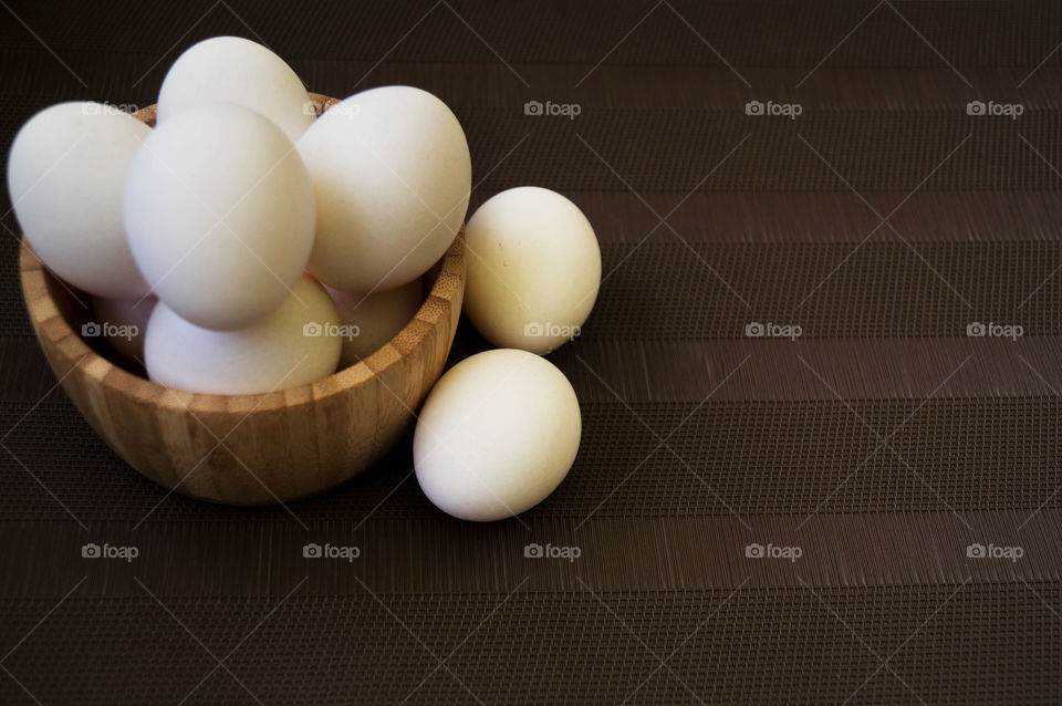 group of eggs closeup in natural light with dark brown background