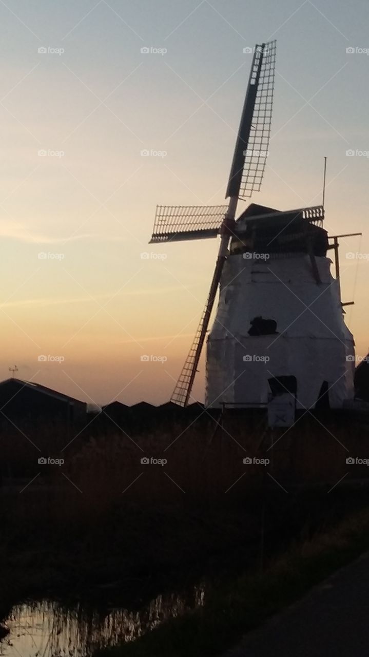 Windmill in scaffolding at sunset
