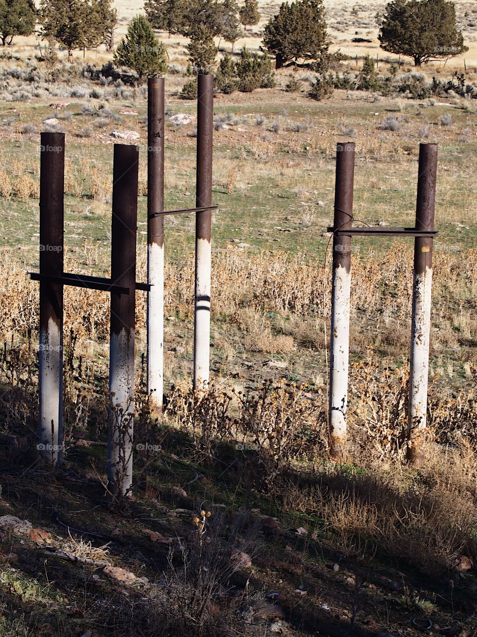 Old pipe frame in the ground showing the history of the area from abandoned industrial site converted to city park in Prineville in Central Oregon on a sunny winter day. 