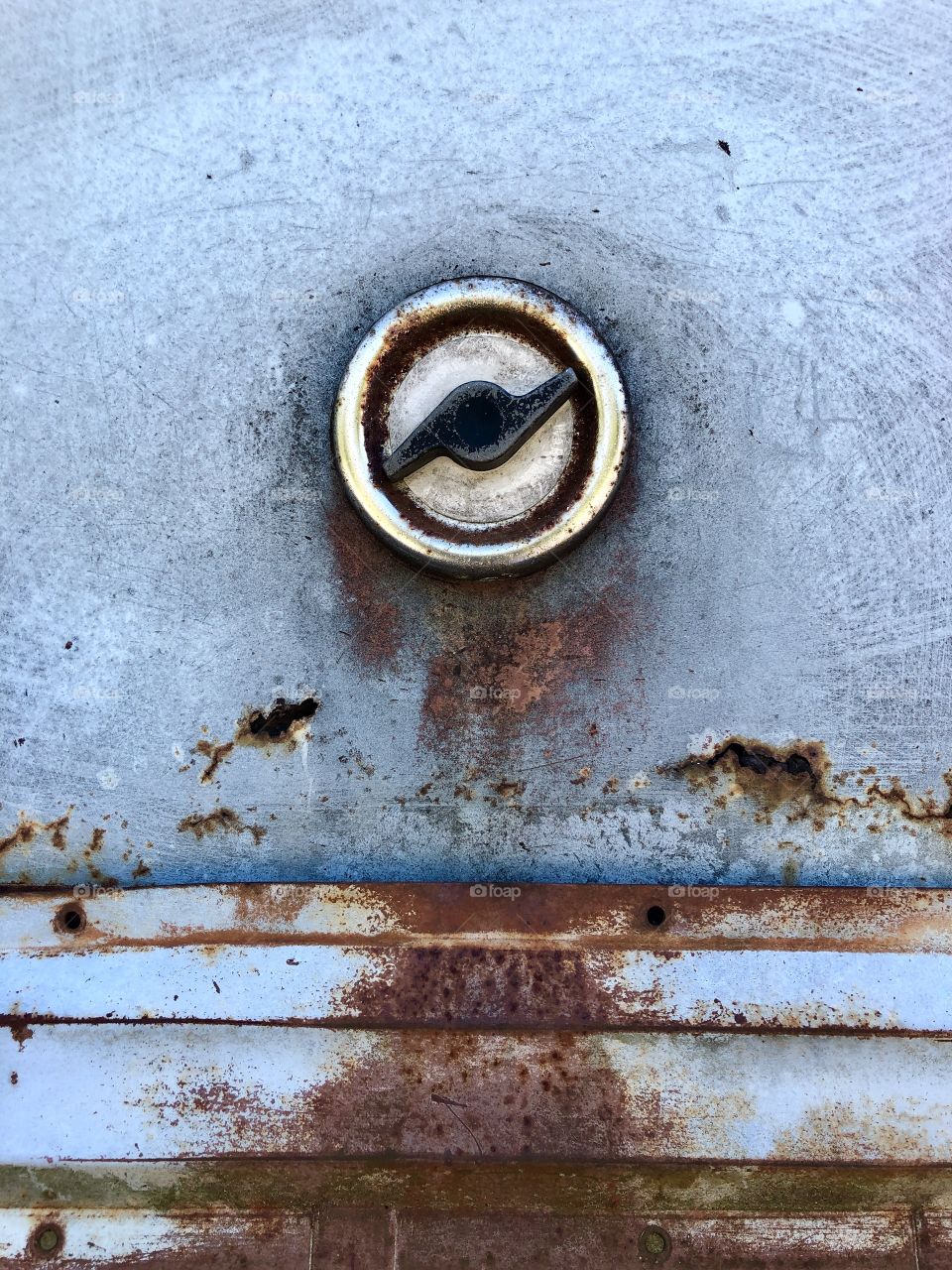 Gas cap on side of old Rusty blue van