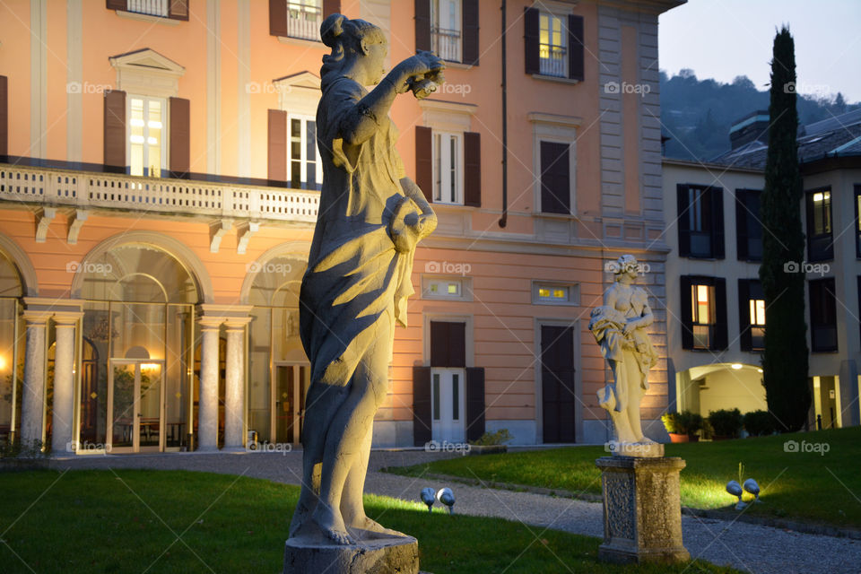 Illuminated statues outside a villa - Como, Lombardy, Italy.