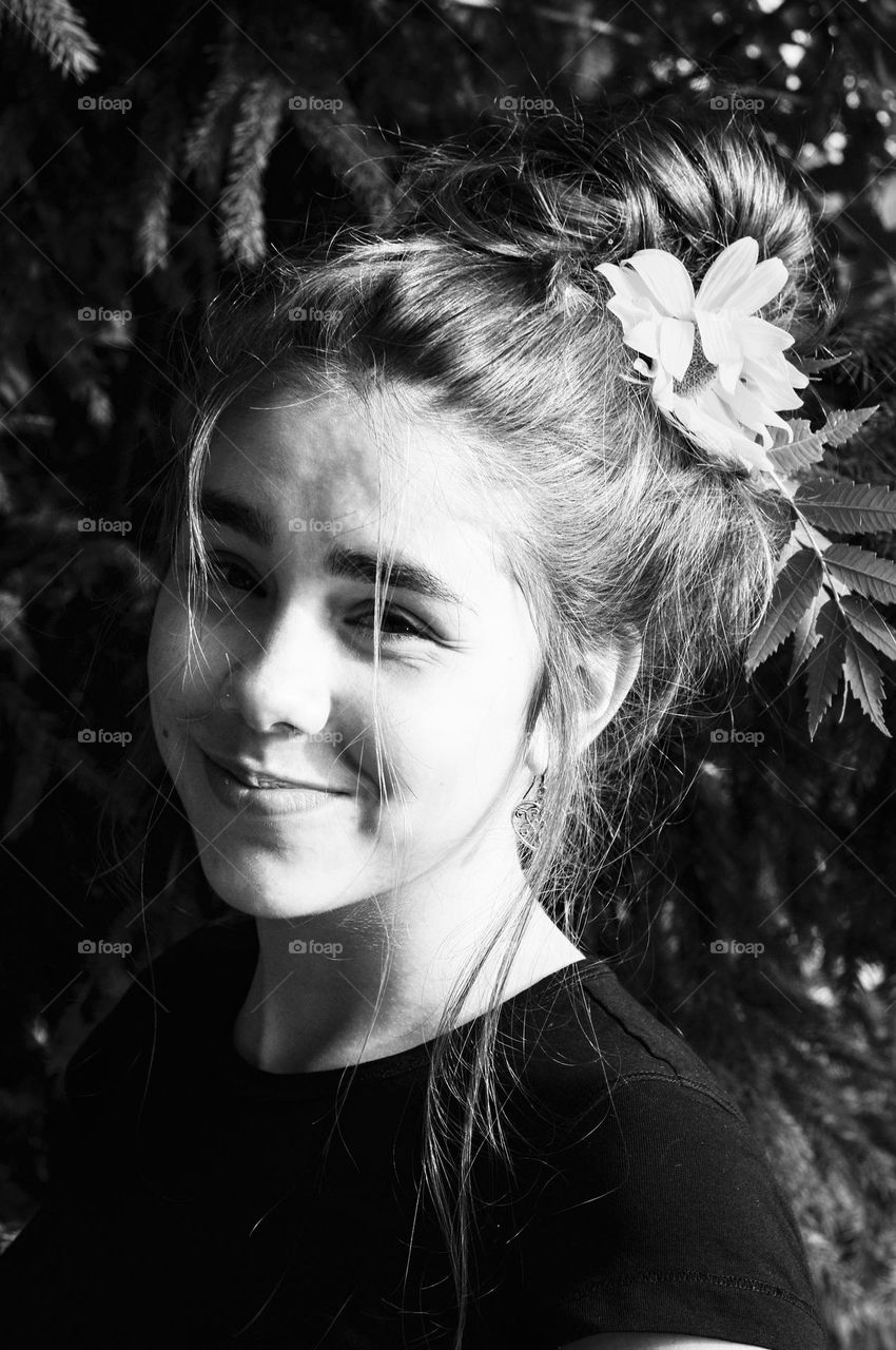 Close-up portrait of a girl. A girl with her hair tied up is caught in the light.