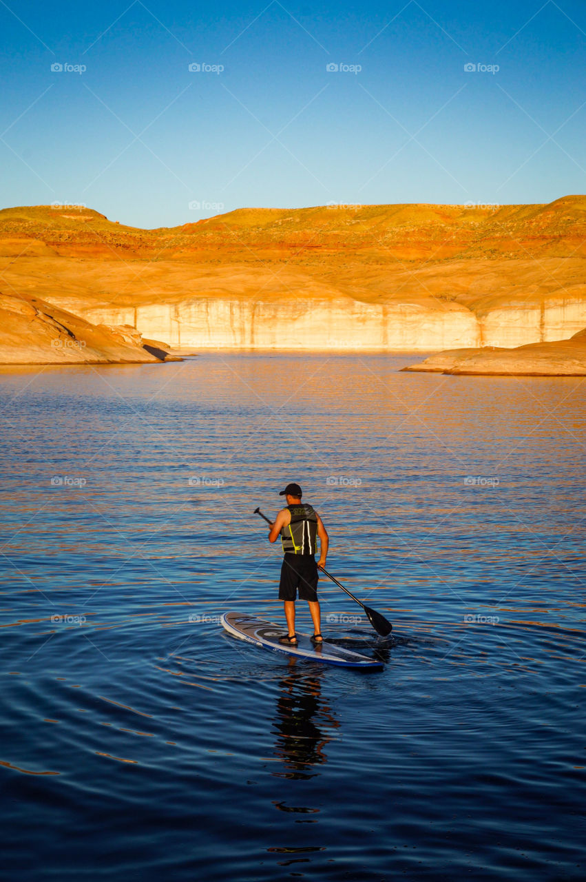 Paddle boarding on Lake Powell in Utah at sunset is great exercise, fun, and beautiful. 
