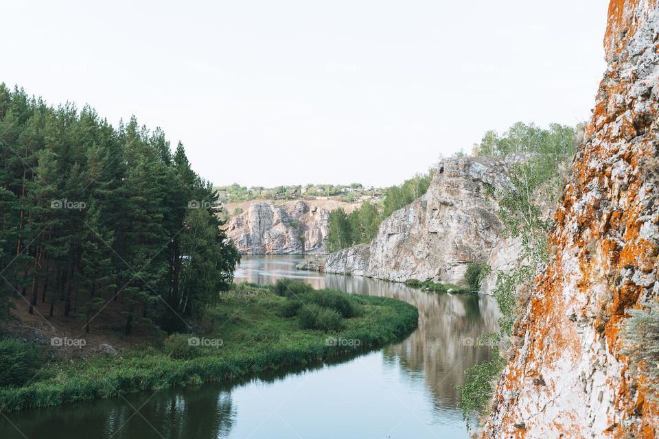 Beautiful view of a wide calm river in the mountains and forest