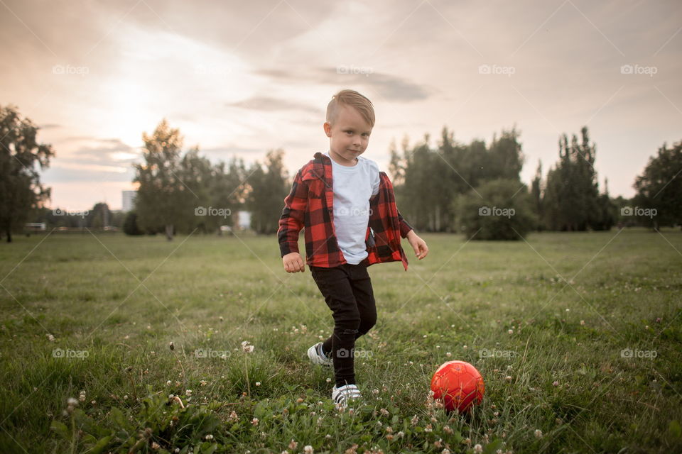 Little boy playing in soccer in a park 