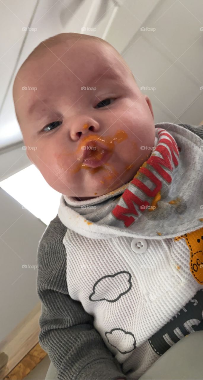 Messy... baby's first bite of sweet potatoes