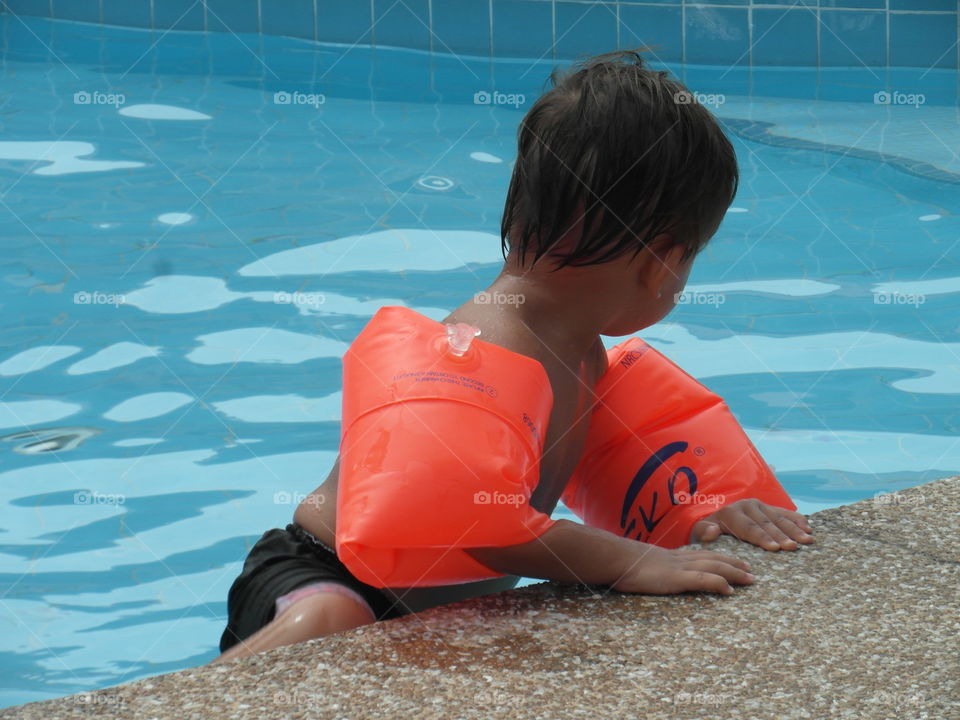 boy climbing out from swimming. done with swimming