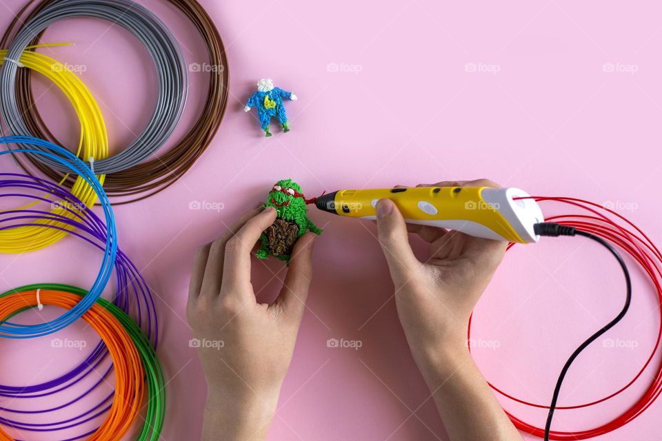 Child creating figures with 3d pen 