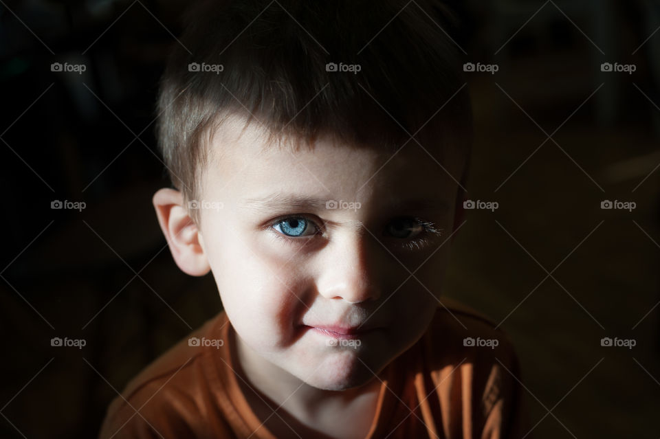 Little boy lit by ambient light.