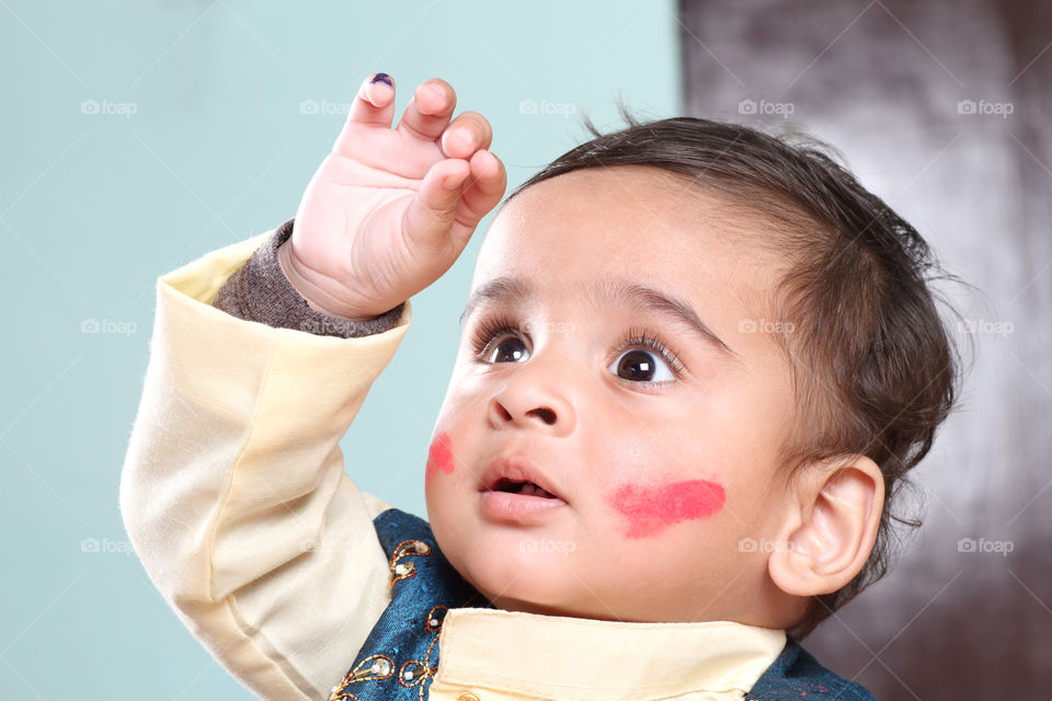 Little boy playing holi in traditional Indian outfit