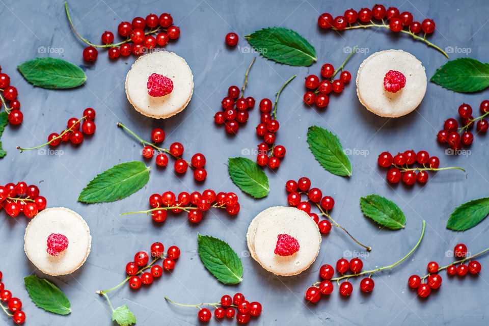 Macaroons and red currant on gray background 