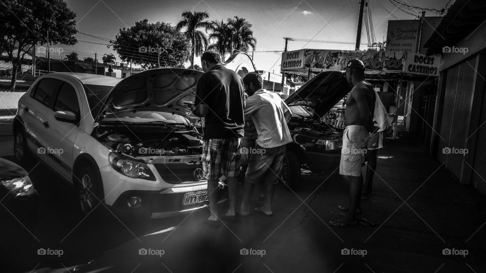 Pessoas, carros, motores, capôs abertos, oficina, defeitos.