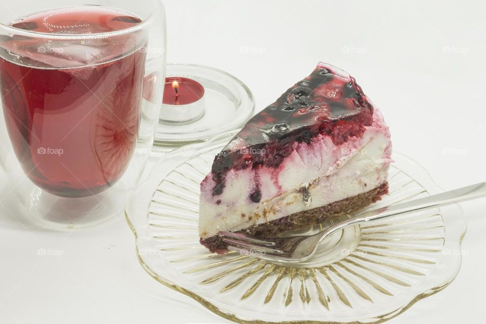 Piece of delicious jelly fruit cake, candle and hibiscus tea. Viva magenta