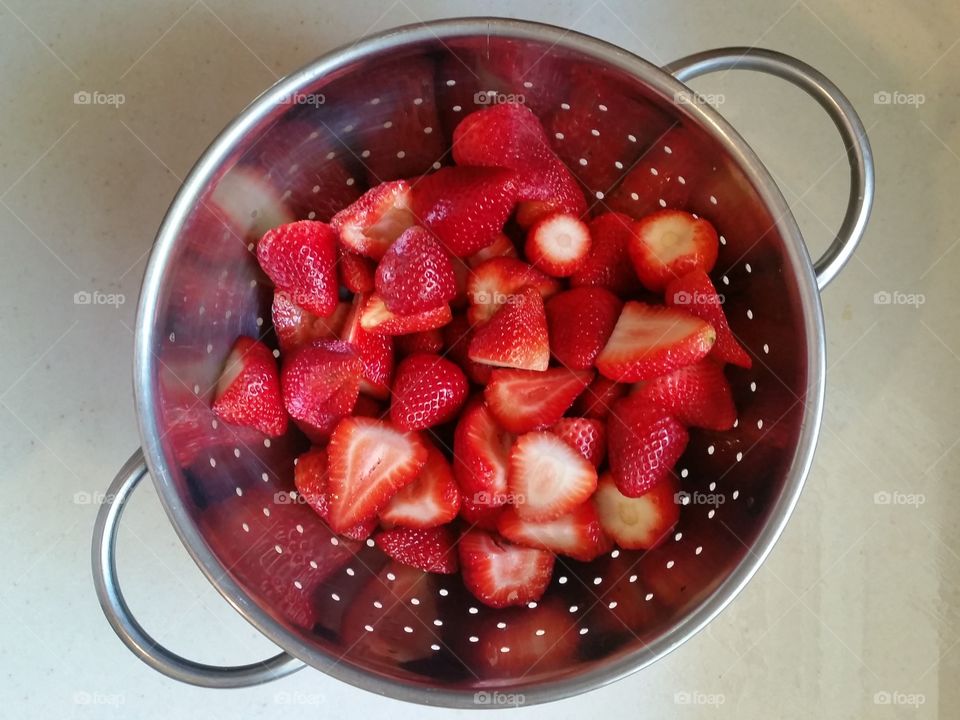 Washing strawberries in colander for making jam and preserves
