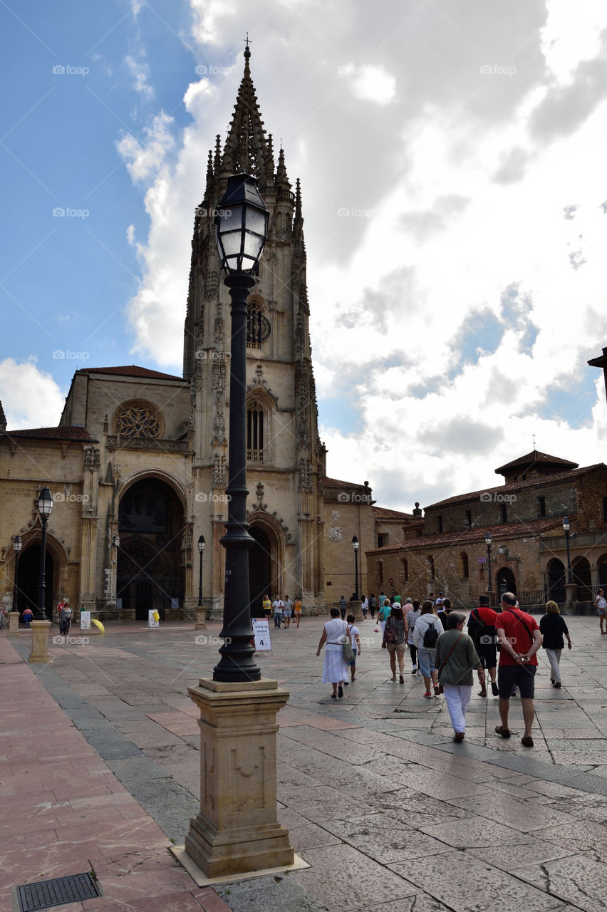 People sightseeing in the city of Oviedo. Cathedral of the Holy Saviour in the background. Asturias, Spain.