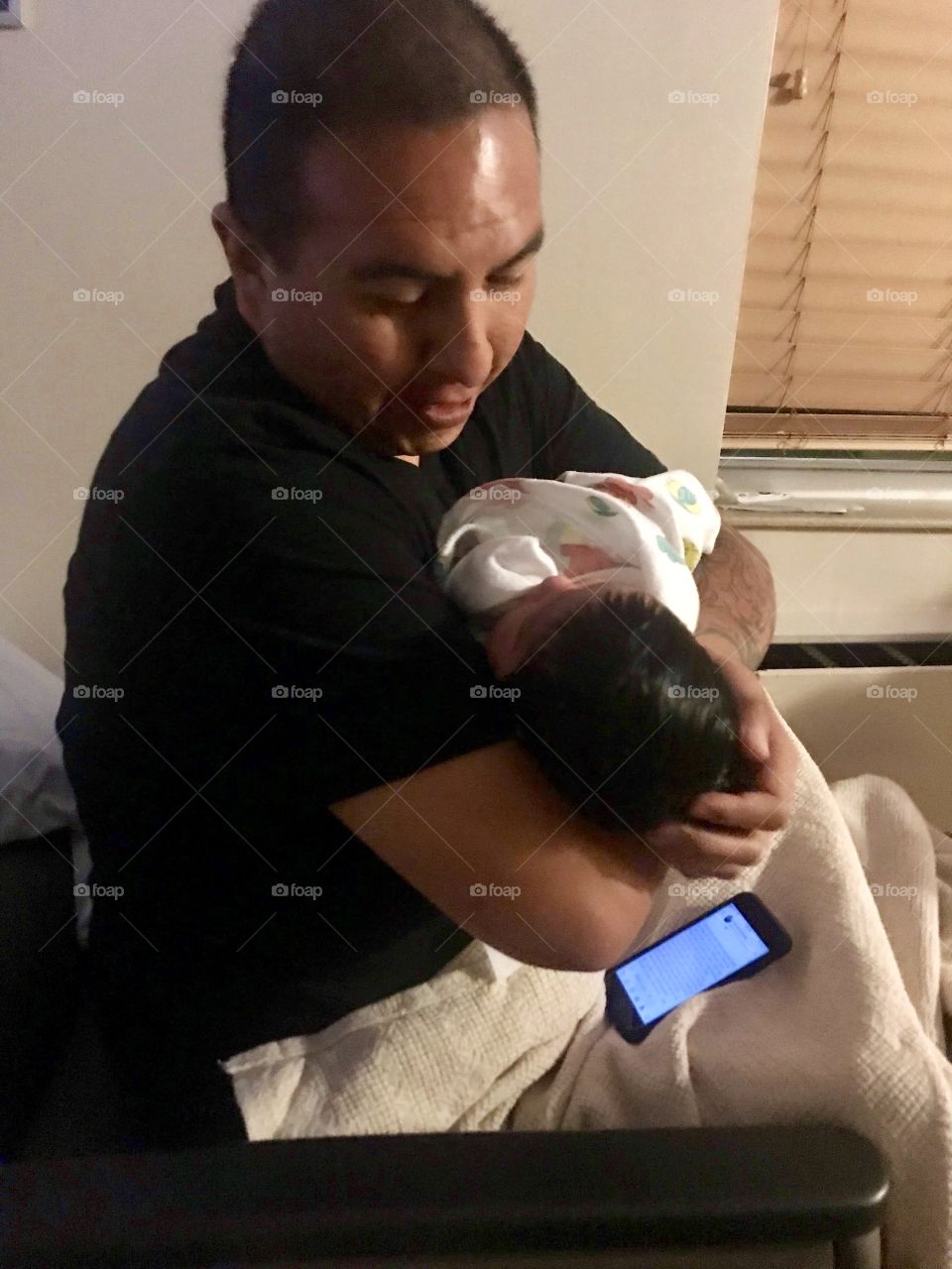 A Native American father holding his new born daughter for the first time.