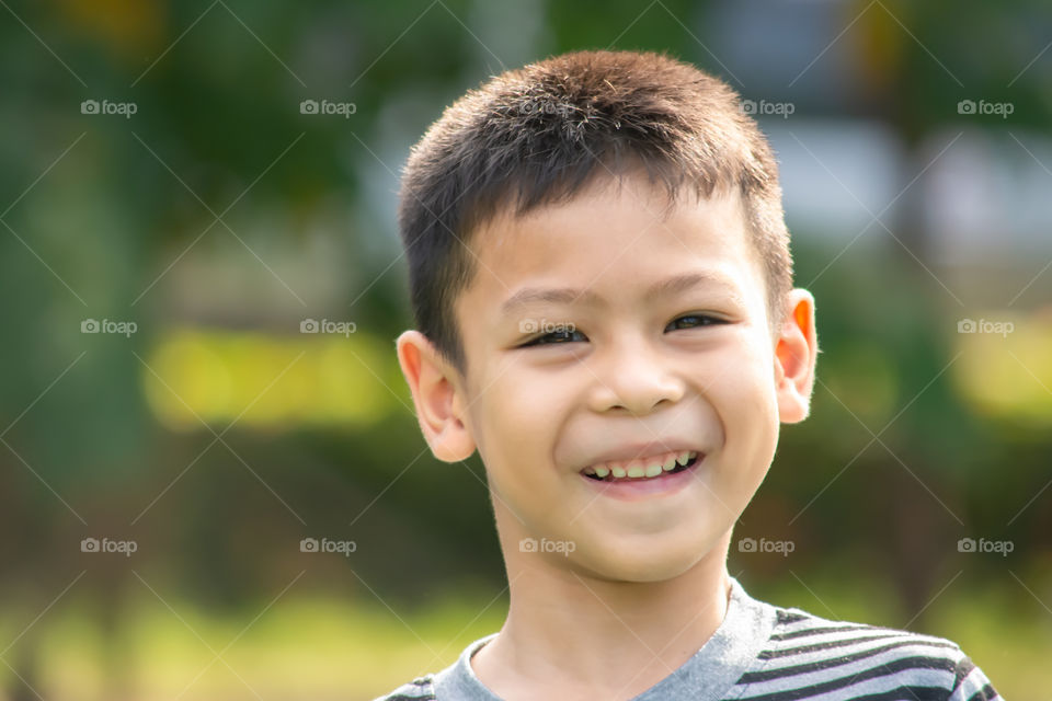 Portrait of a boy Asia, laughing and smiling happily in the park.