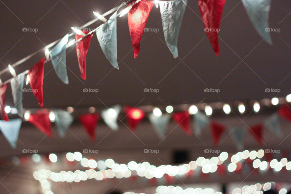 Paper bunting and fairy lights adorn the ceiling of a reception