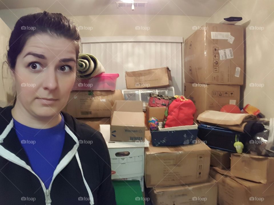 Portrait of a woman standing in front of cardboard boxes