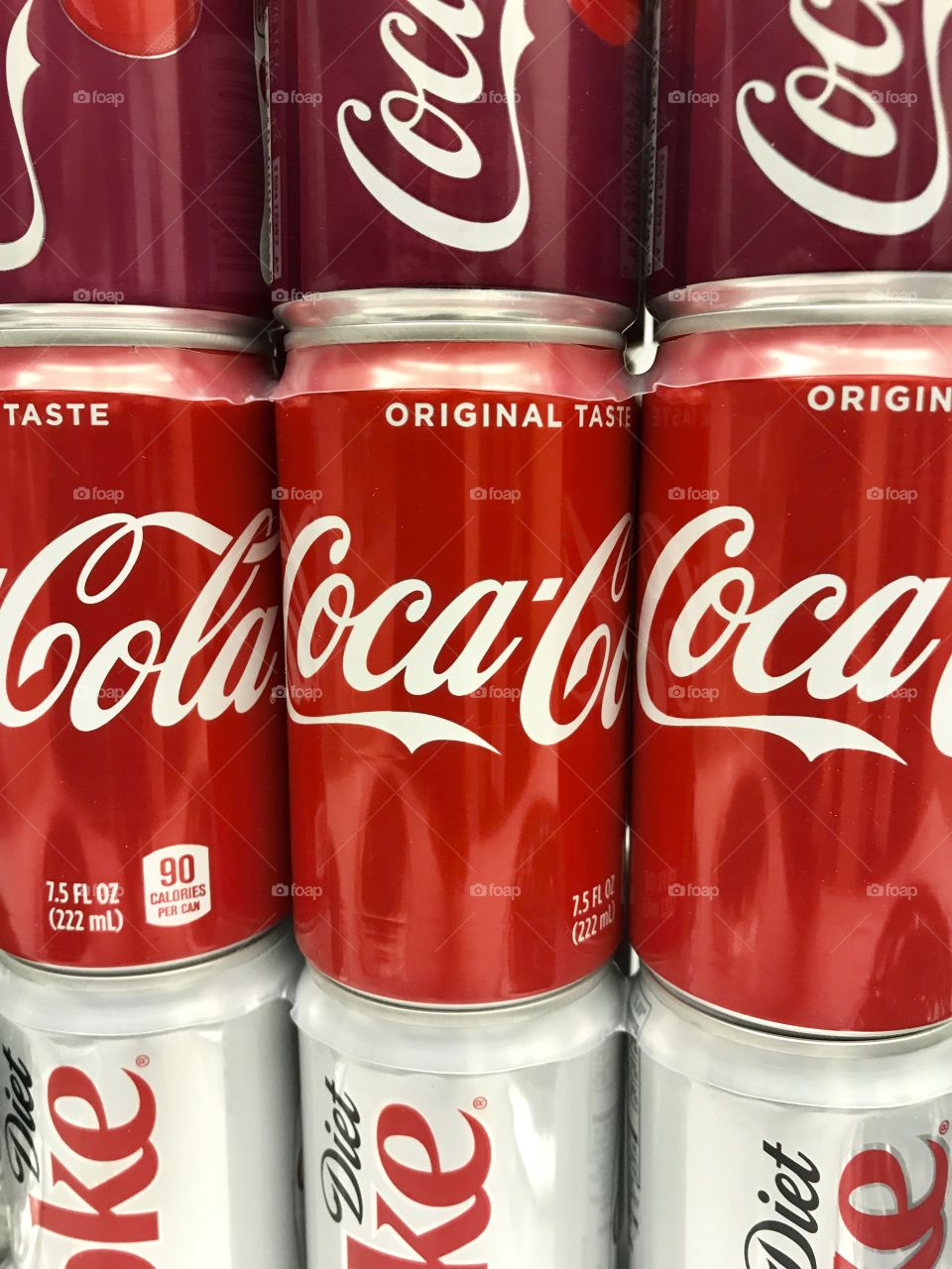 Three different types of coke cans with classic Coca Cola being featured