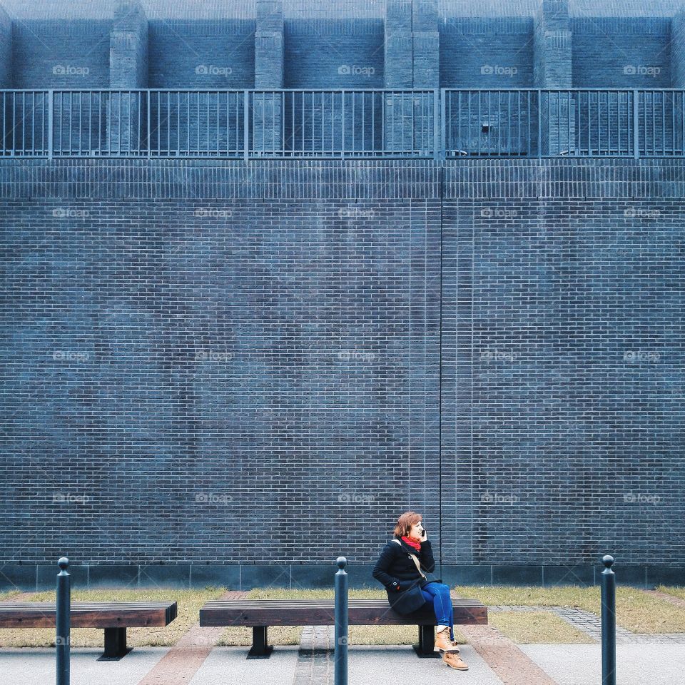 Woman sitting on bench speaking on mobile phone