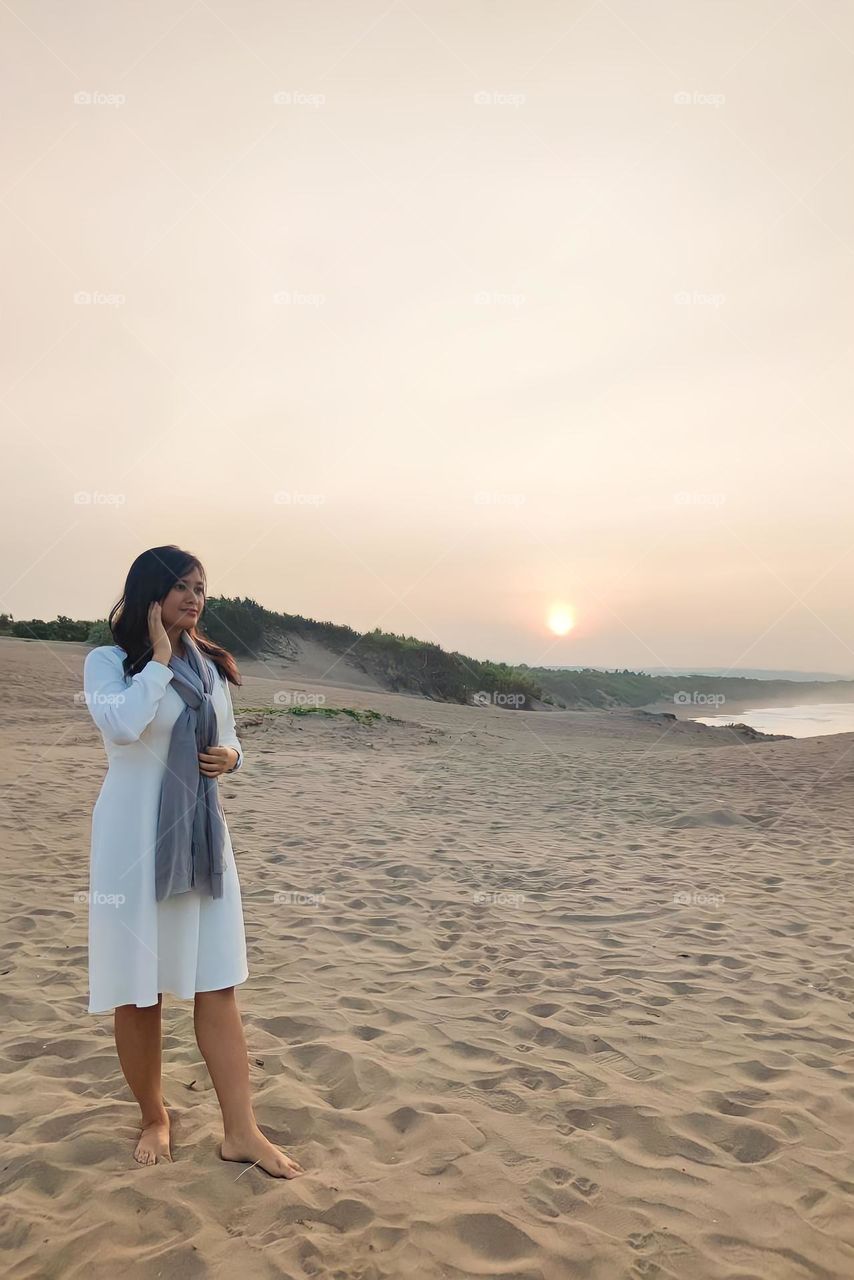 Portrait of a young woman on holiday on a white sand beach on a sunny afternoon