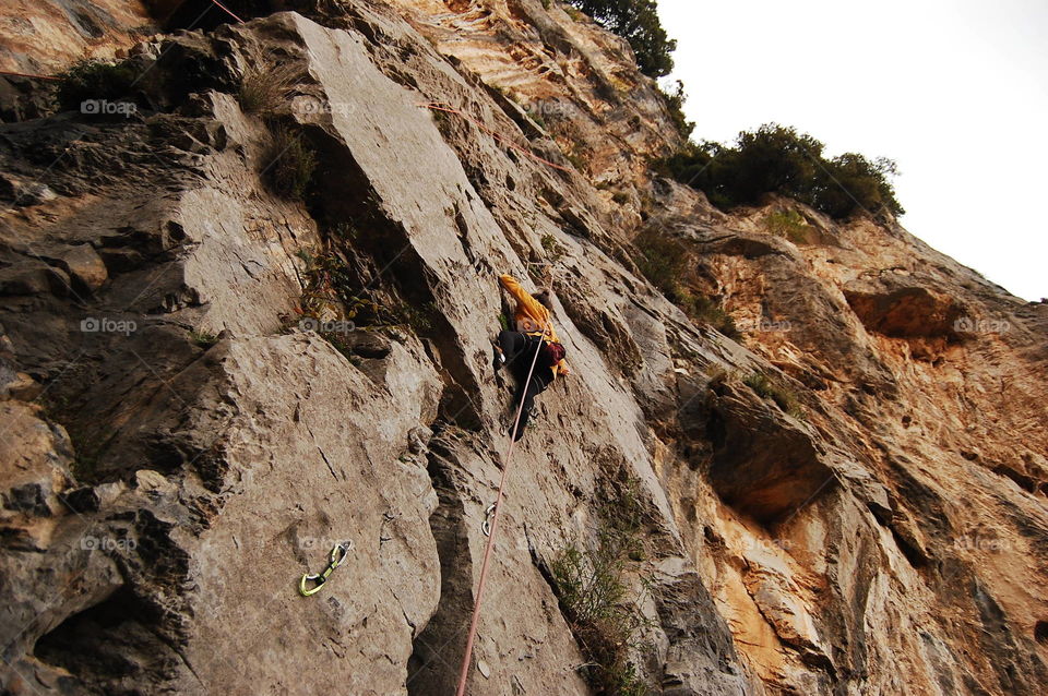 Low angle view of woman climbing on rock