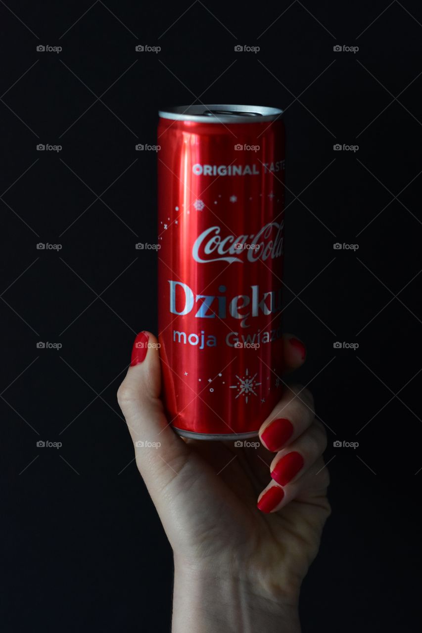 holding cola on black background