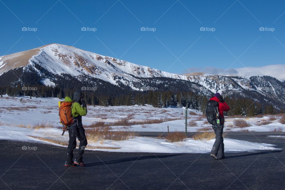 Men walking on a closed winter road in a mountain valley