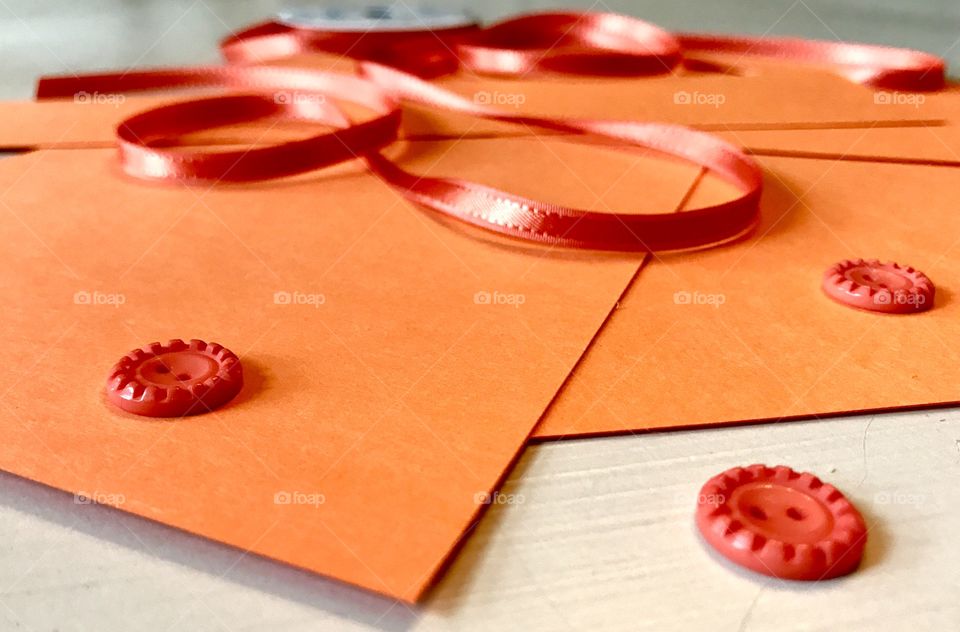 Orange paper with button and ribbon