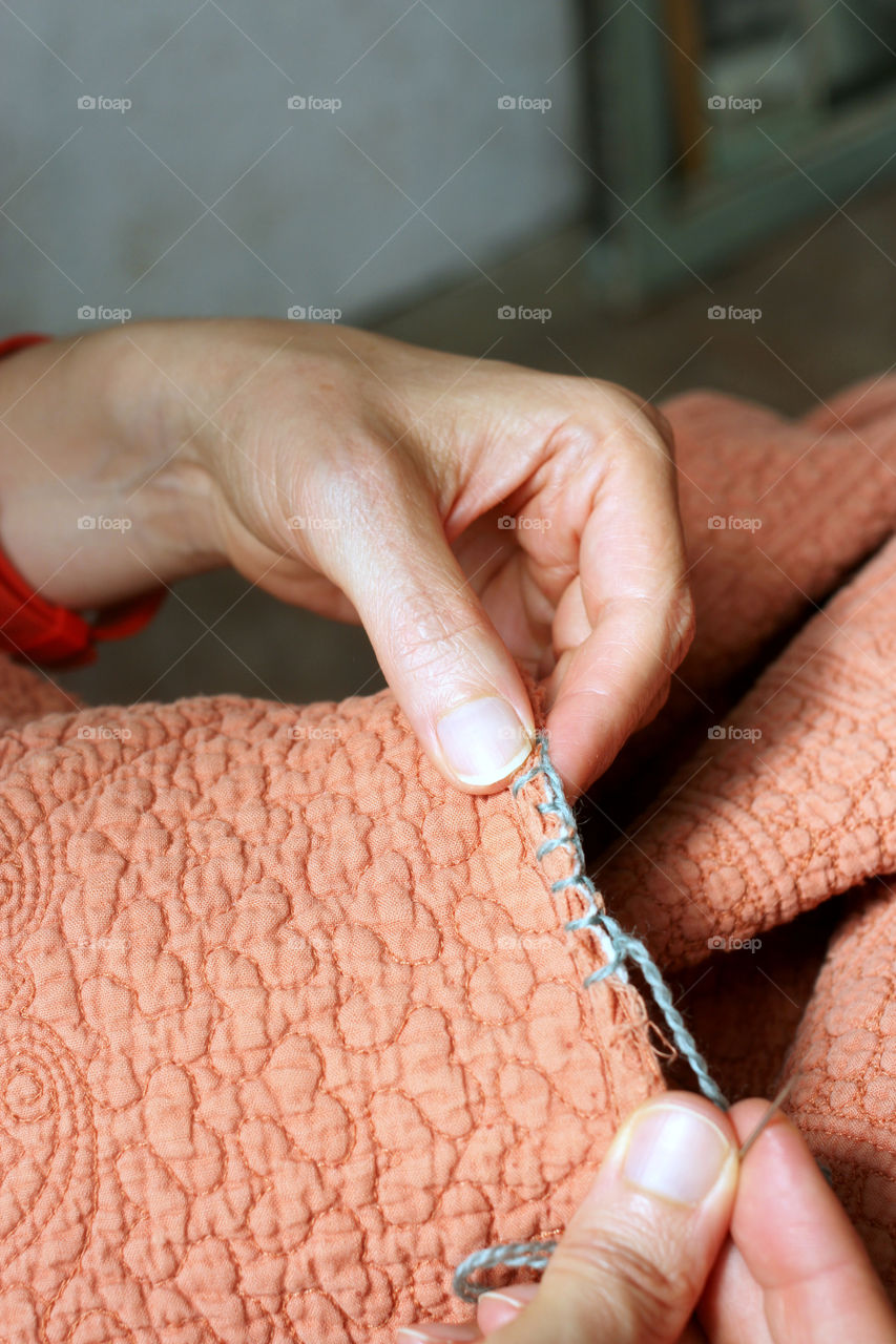 Close-up of woman Mending a quilt