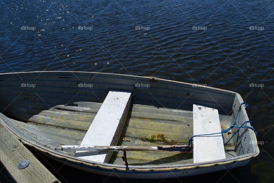 Rusty old rowboat in ocean at dock