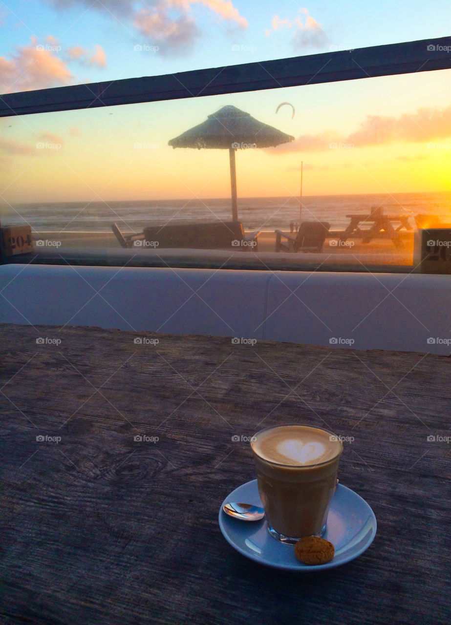 Cup of coffee with a heart at sunset