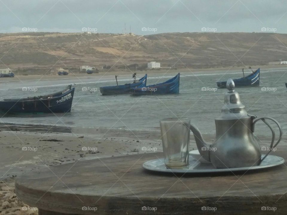 Best moment with a cup of tea near the beach and boats.