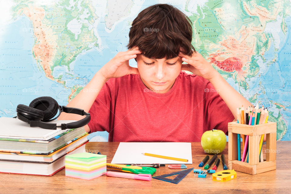 Boy doing his homework. Young boy thinking about his homework