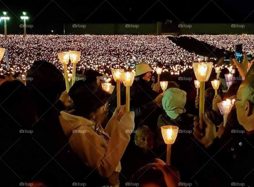 Crowd of people holding candles