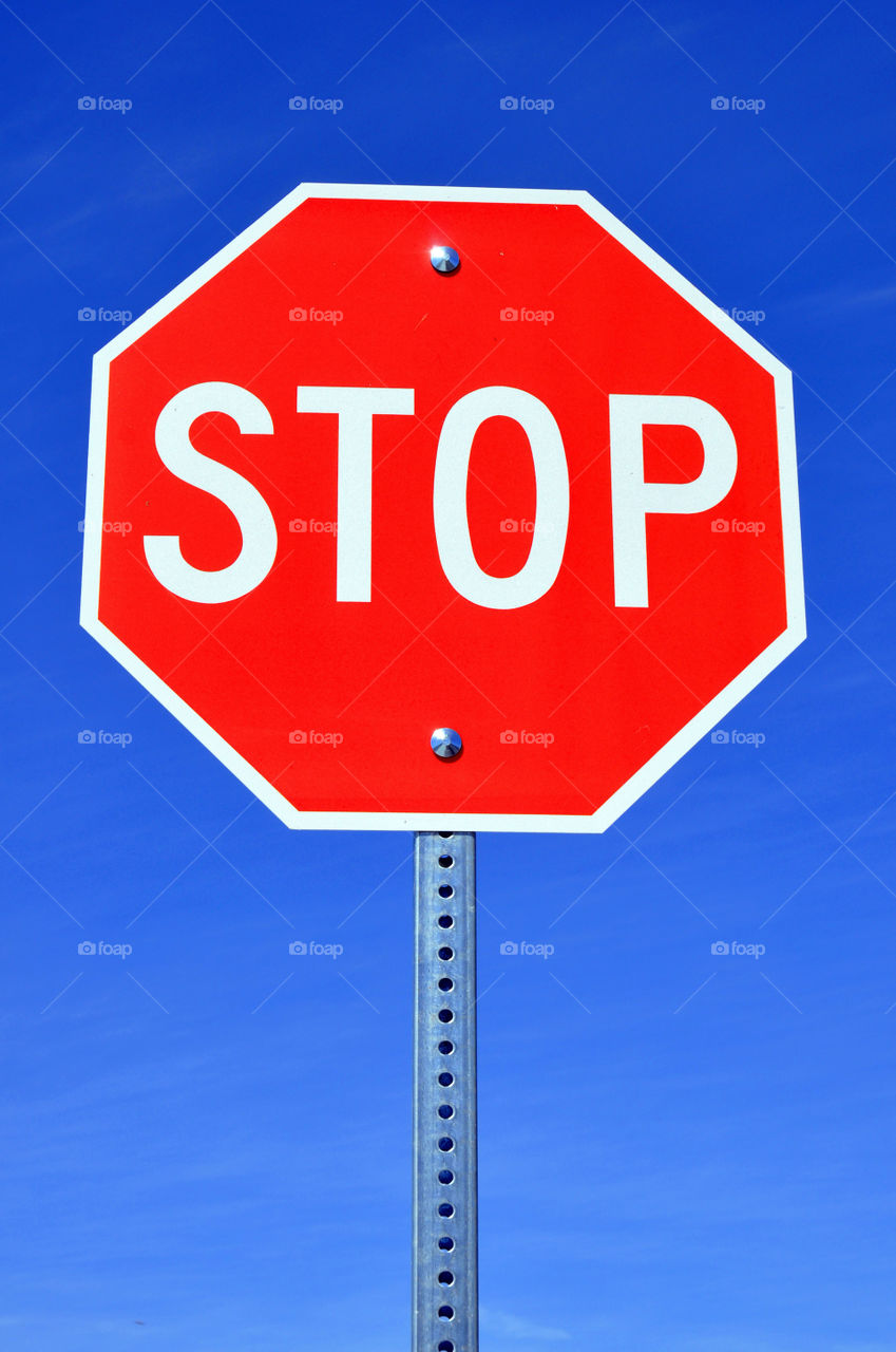 Stop sign against a pretty blue sky.
