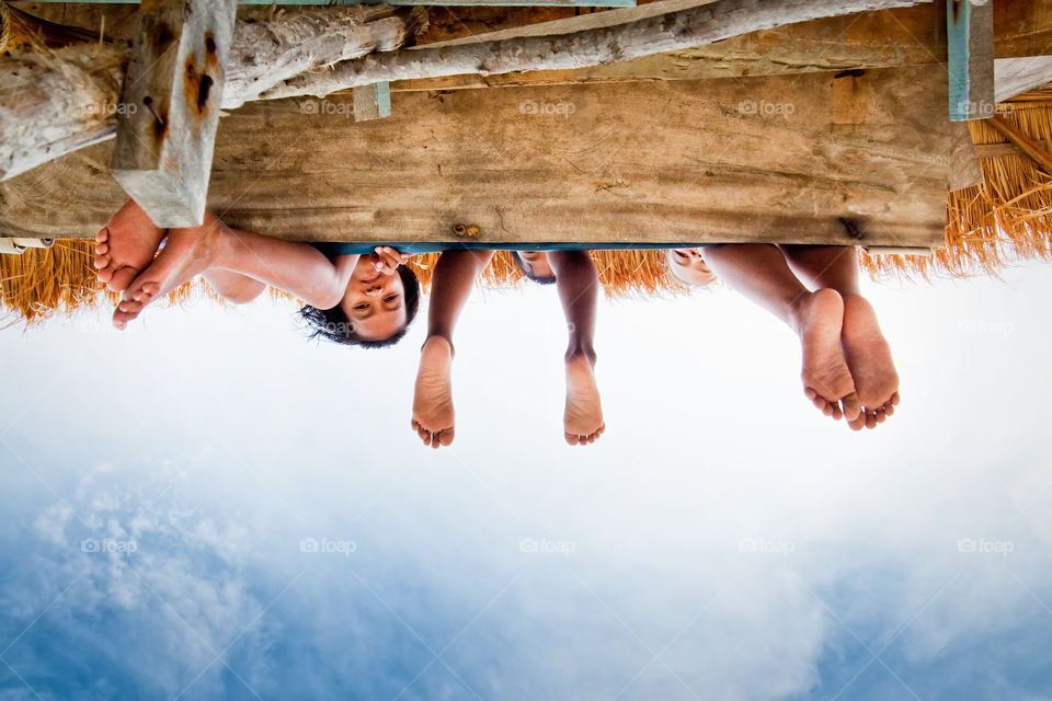 foot in the sky. children sit on the bridge 