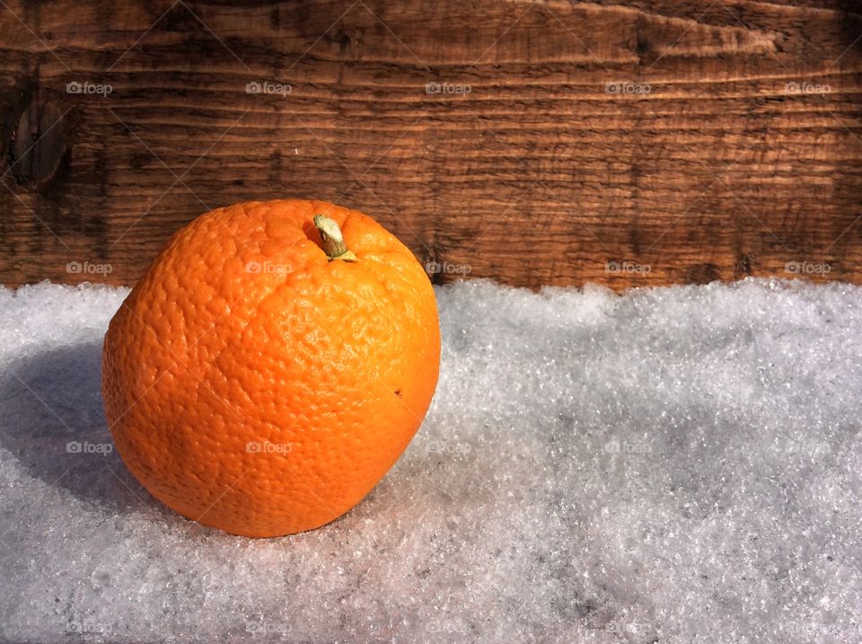 An orange on the snow