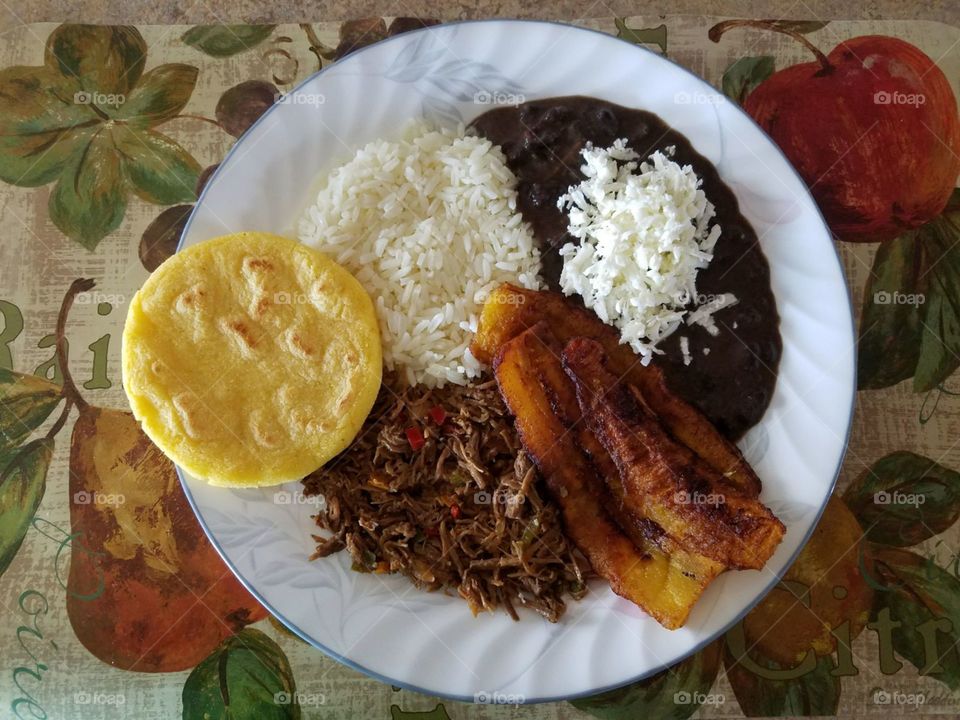 Pabellon, shredded beef, black beans, shredded white cheese, rice, arepa, fried plantains 